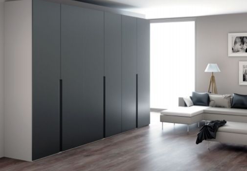 Sala de estar moderna y minimalista con armario gris oscuro, sofá, lámpara de pie y ventana luminosa.