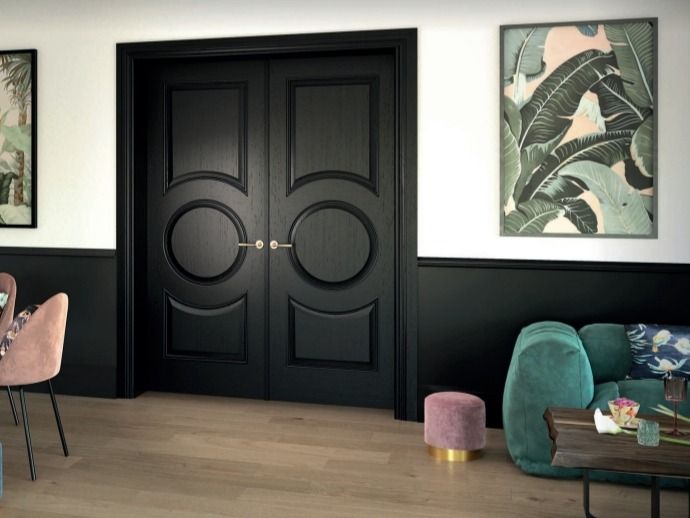 Sala de estar moderna con puertas dobles negras, arte mural tropical, silla color turquesa y suelo de madera clara.