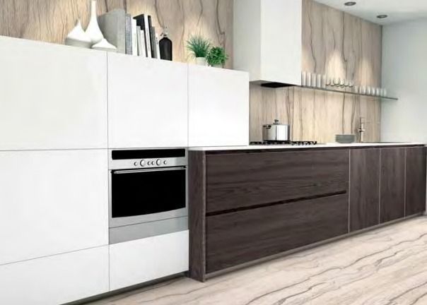 Cocina moderna minimalista con gabinetes blancos, gabinetes inferiores de madera oscura, horno empotrado y piso de madera clara.