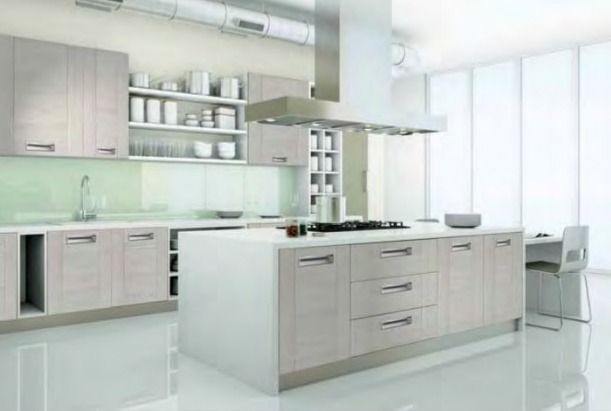 Cocina moderna blanca con isla, armarios de madera clara y grandes ventanales.