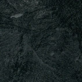 Primer plano oscuro y granulado de una superficie negra texturizada con formas tenues en condiciones de poca luz.