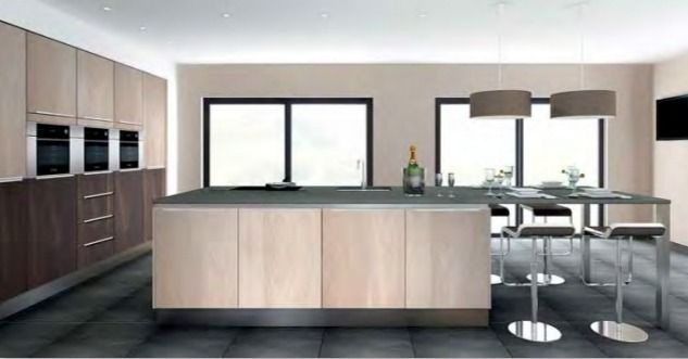 Cocina moderna con isla de madera clara, armarios oscuros y mesa de comedor junto a grandes ventanales.