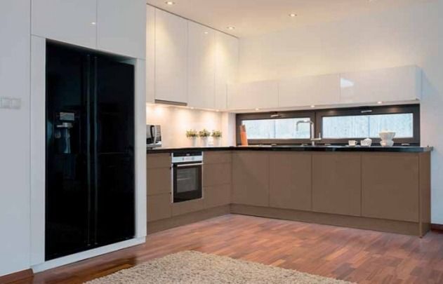 Cocina moderna con armarios oscuros, suelo de madera y una amplia ventana sobre la encimera.