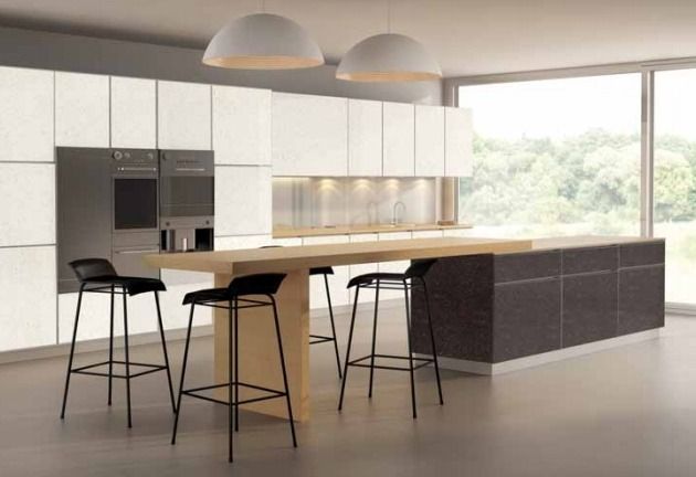 Cocina moderna blanca con isla, taburetes de bar negros, lámparas colgantes y gran ventanal.
