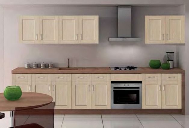 Cocina moderna con gabinetes color crema, encimeras de madera, estufa y una pequeña mesa redonda en primer plano.