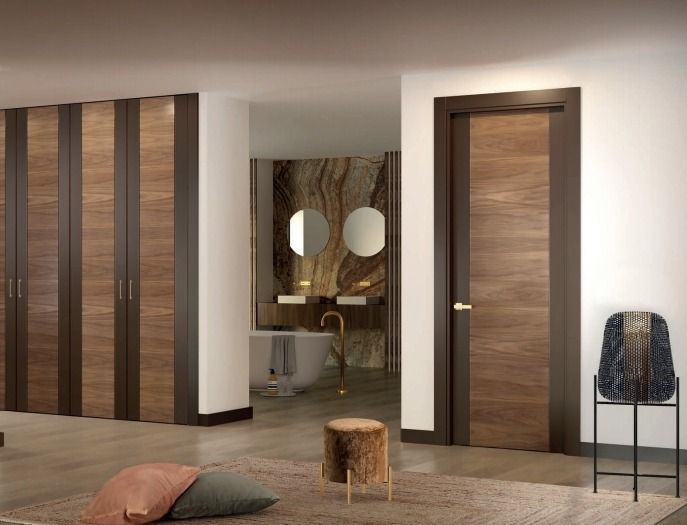 Dormitorio moderno con paredes revestidas de madera, dos puertas y un tocador visible a través de la abertura central.