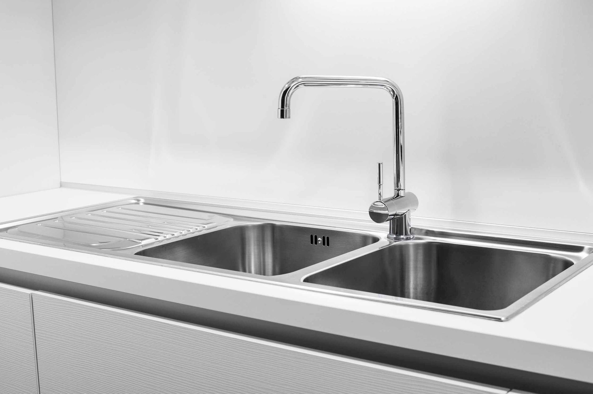 Fregadero de cocina moderno de acero inoxidable con doble cubeta y grifo cromado.