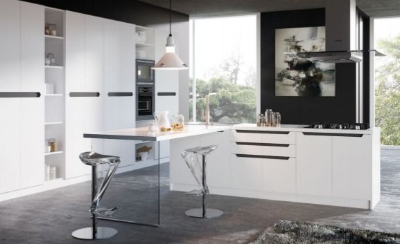 Cocina moderna blanca con isla, taburetes de bar, lámparas colgantes y una gran ventana con vistas a la vegetación.