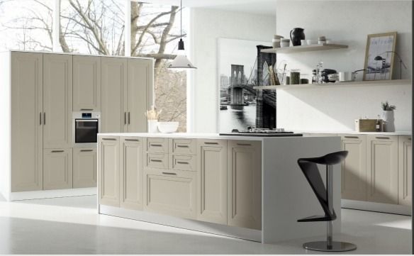Cocina moderna blanca con isla, hornos empotrados y taburetes negros junto a estantes abiertos.
