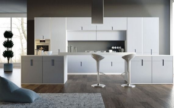 Cocina moderna minimalista con gabinetes blancos, isla gris y dos taburetes blancos.