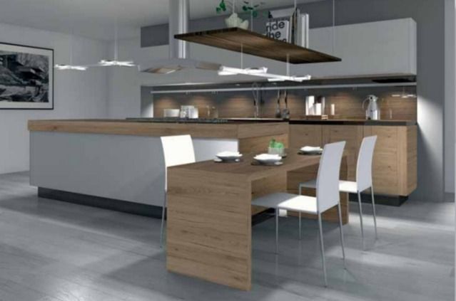Cocina moderna con isla de madera, armarios blancos, taburetes de bar y lámparas colgantes.