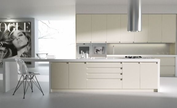 Cocina moderna minimalista con gabinetes blancos, isla y taburete cromado en un espacio abierto y luminoso.
