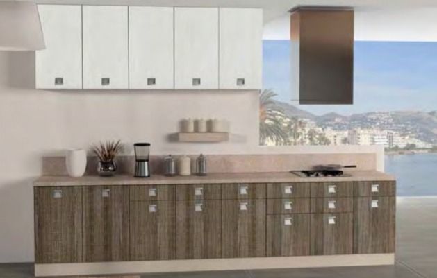 Cocina moderna con armarios superiores blancos, armarios inferiores de madera y un gran ventanal con vistas a una ciudad costera.