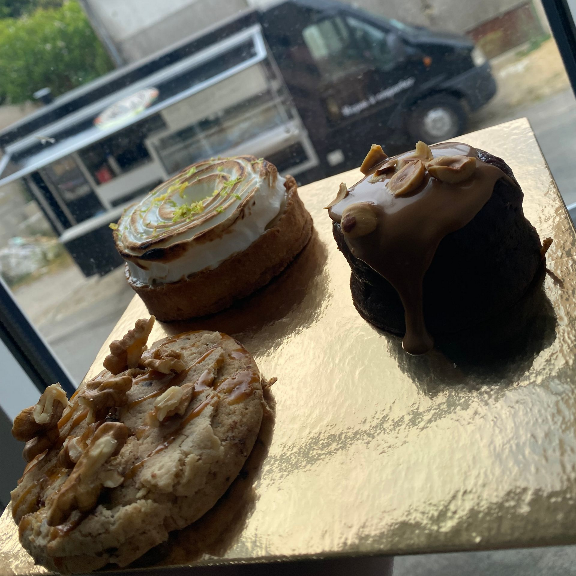 Trois desserts sur un plateau devant un food truck