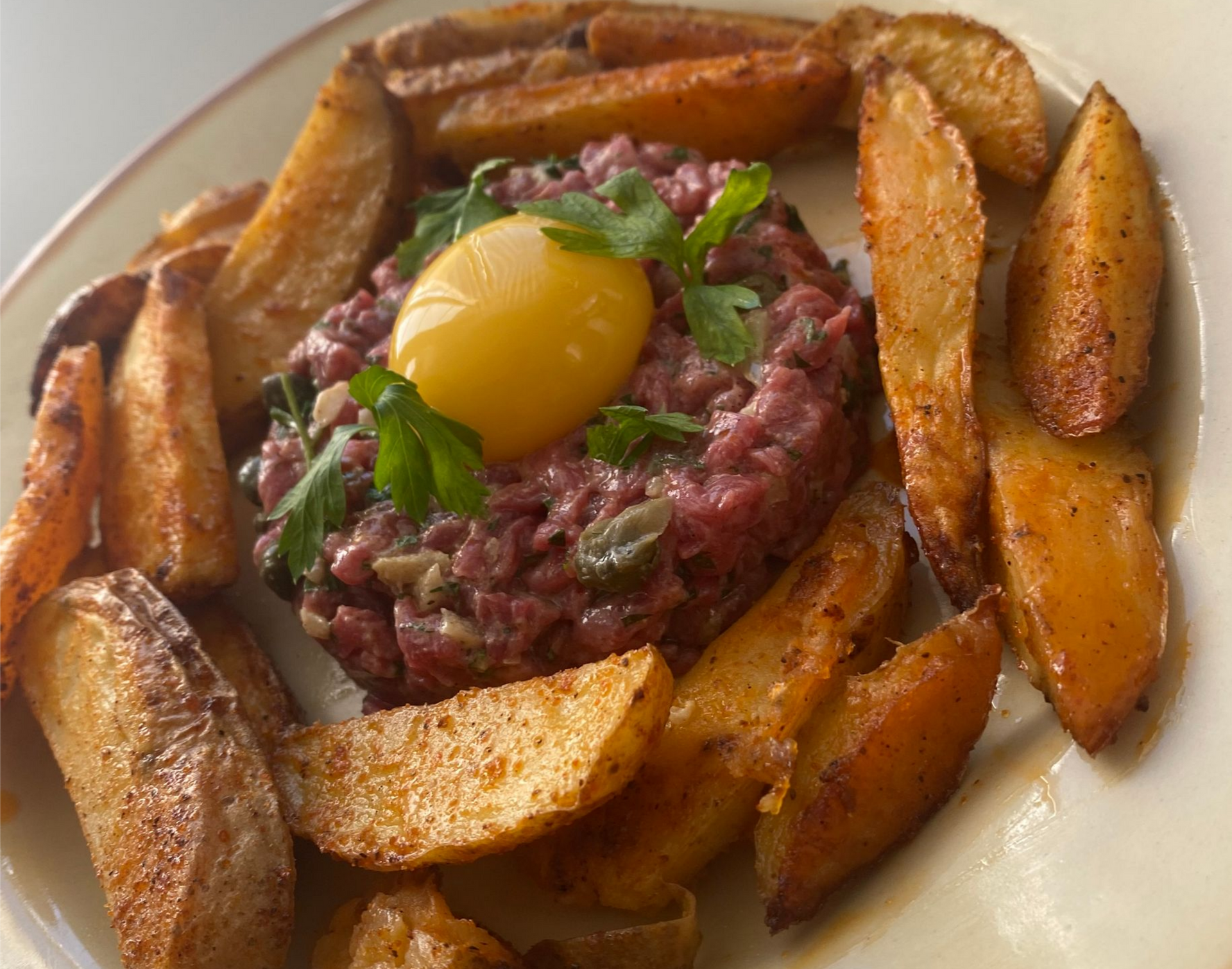 Un tartare avec des potatoes dans une assiette