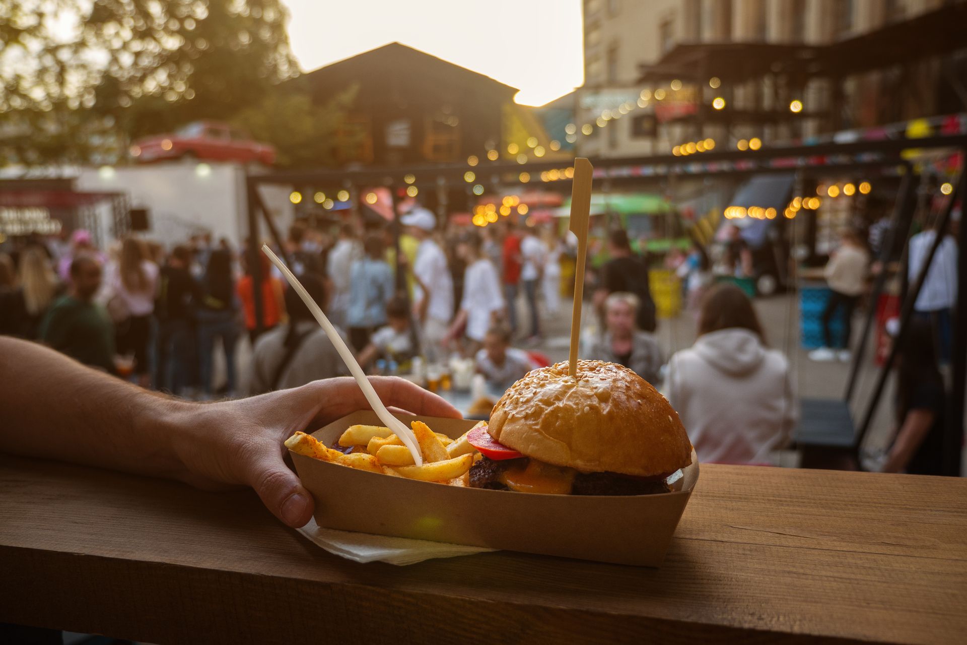 Un burger avec des frites sur le comptoir d'un food truck durant une fête de village