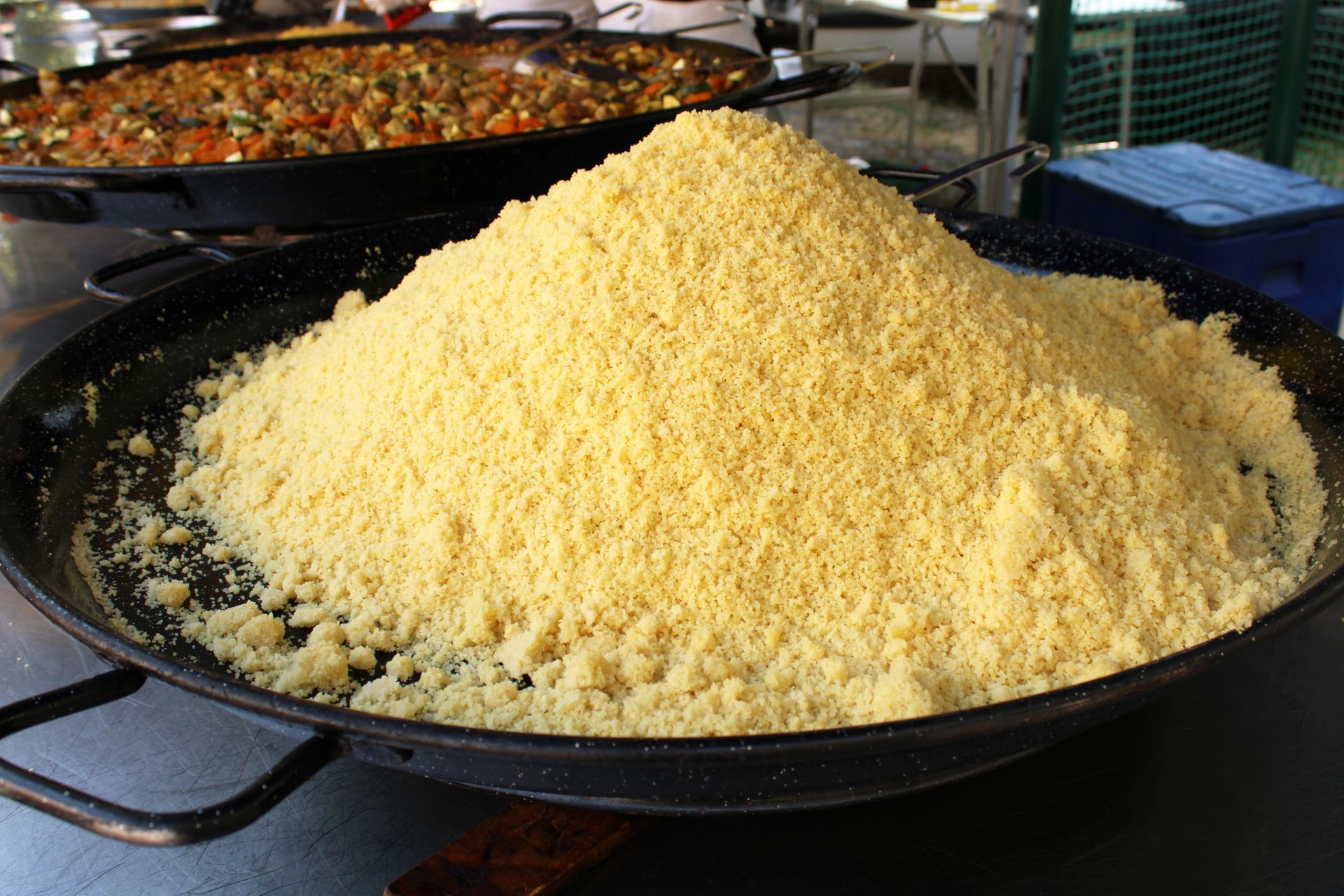 Préparation d'un couscous dans deux poêles géantes