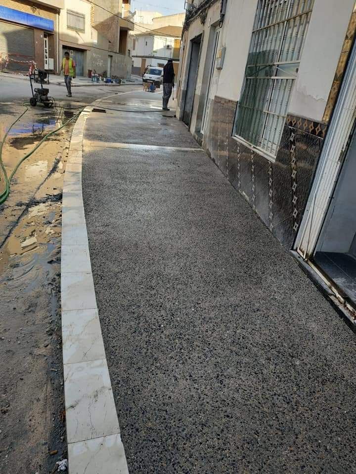 Un hombre camina por una acera al lado de un edificio.