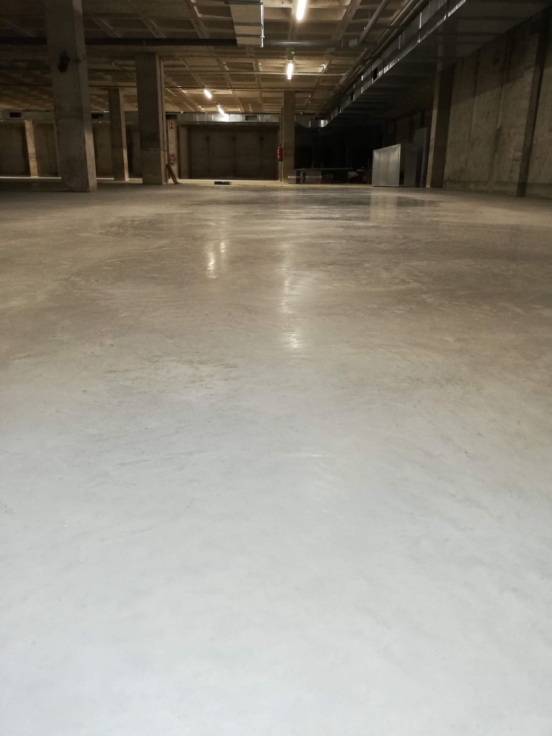 Un gran almacén vacío con suelo de hormigón blanco.