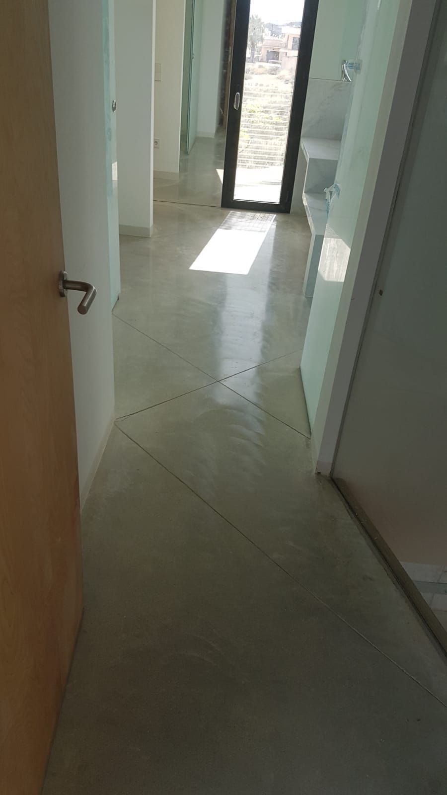 Un pasillo con una puerta y una ventana en una casa.