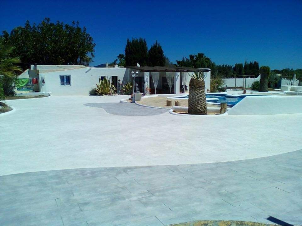 Un gran edificio blanco con una piscina enfrente.