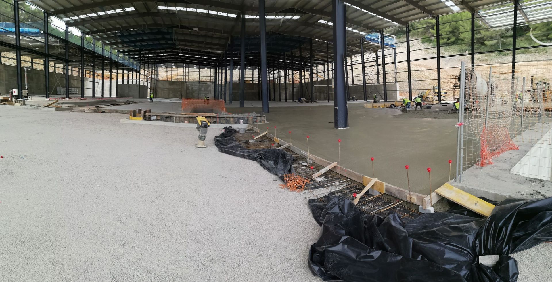 Un gran edificio en construcción con piso de concreto.