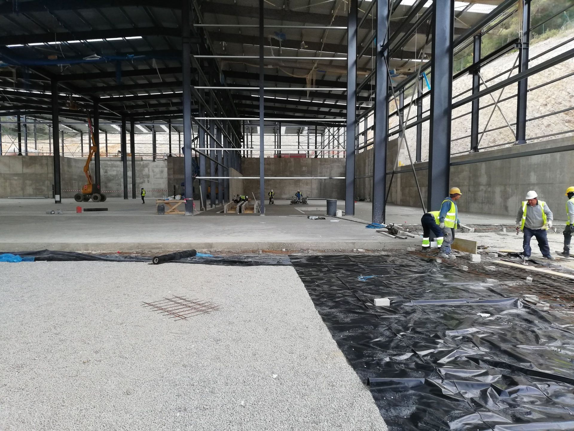 Un grupo de trabajadores de la construcción está trabajando en el piso de un edificio en construcción.