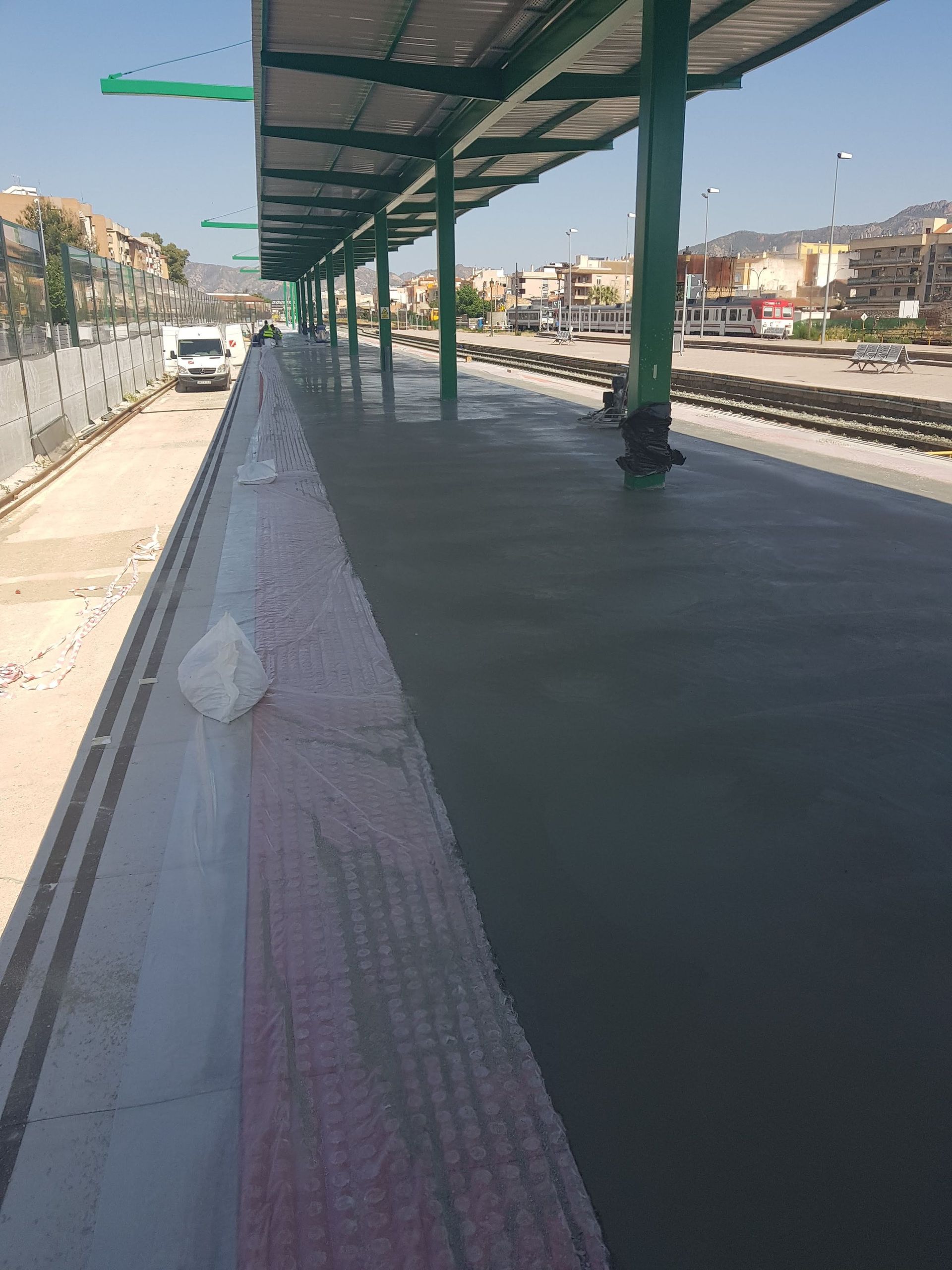 Una estación de tren con un dosel verde sobre el andén