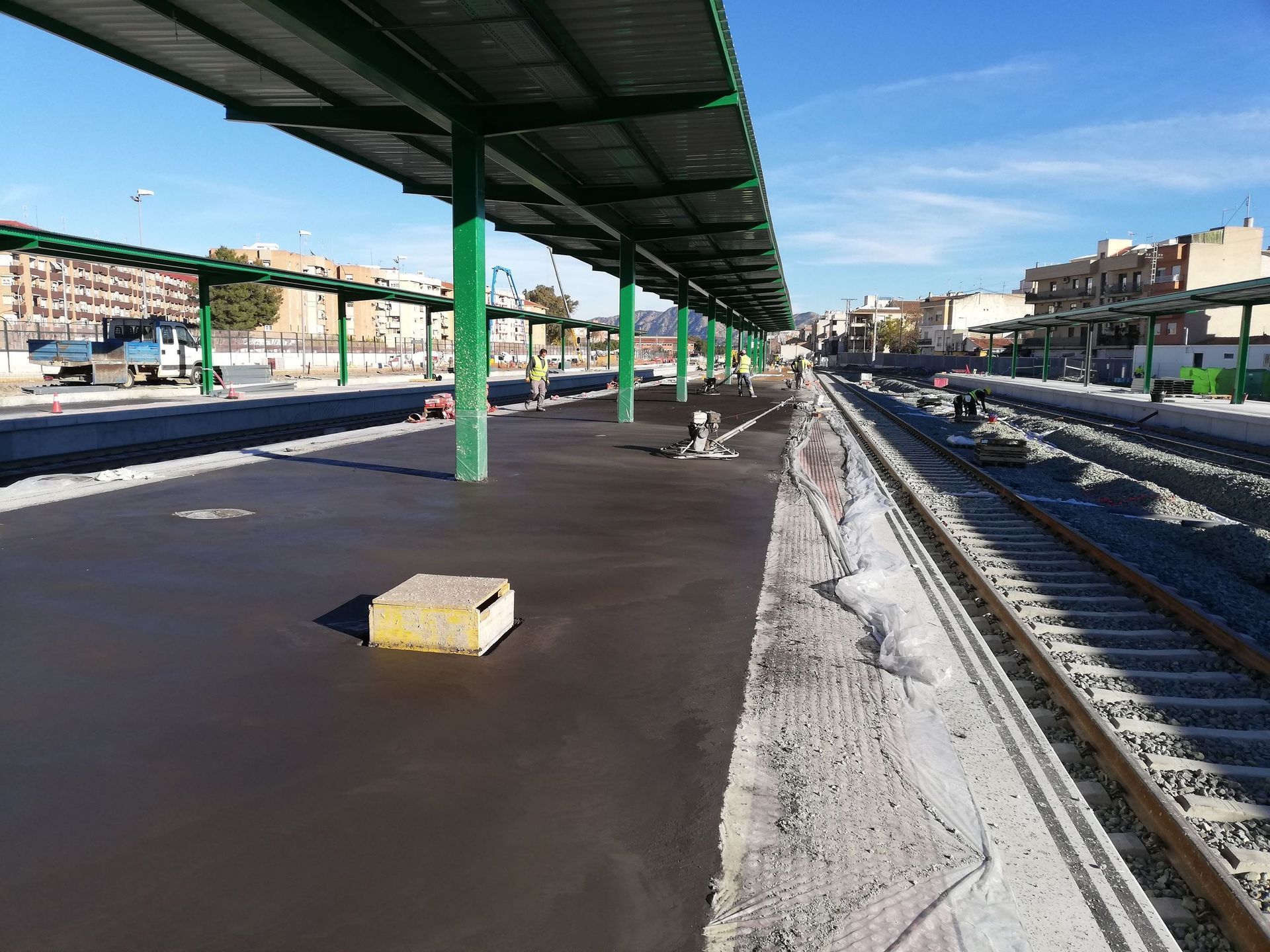 Una estación de tren con un dosel verde sobre las vías