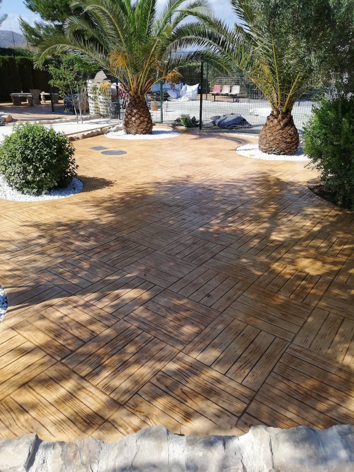 Una pasarela de ladrillos con palmeras al fondo.