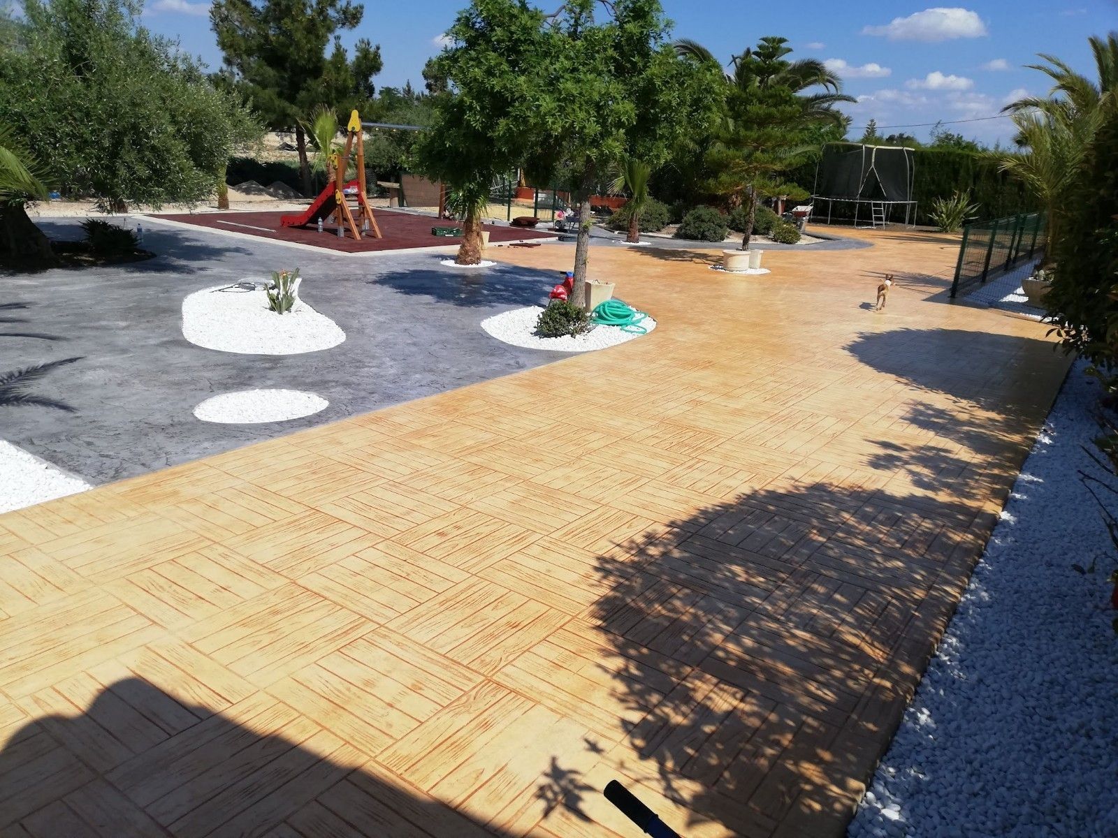Un patio con un parque infantil al fondo