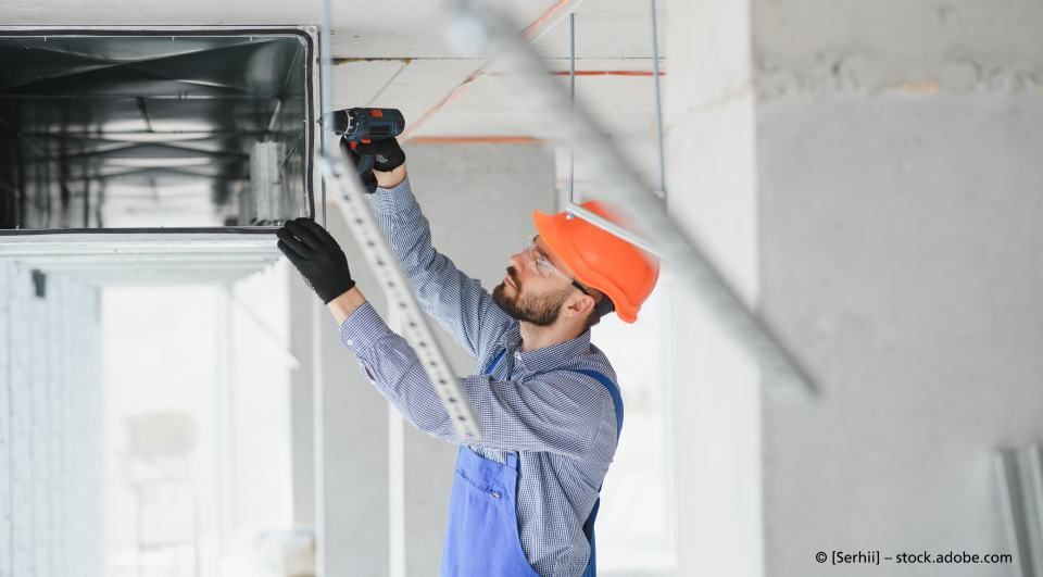 Toni Ansmann, Heizungs- und Lüftungsbau - GmbH, Mitarbeiter installiert Gerät an Decke