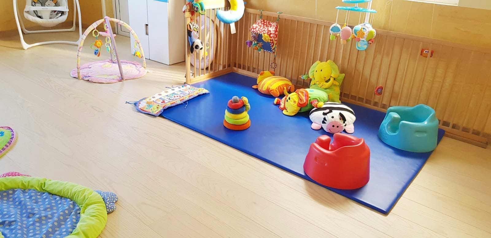 Una habitación llena de muchos juguetes y una alfombra azul.