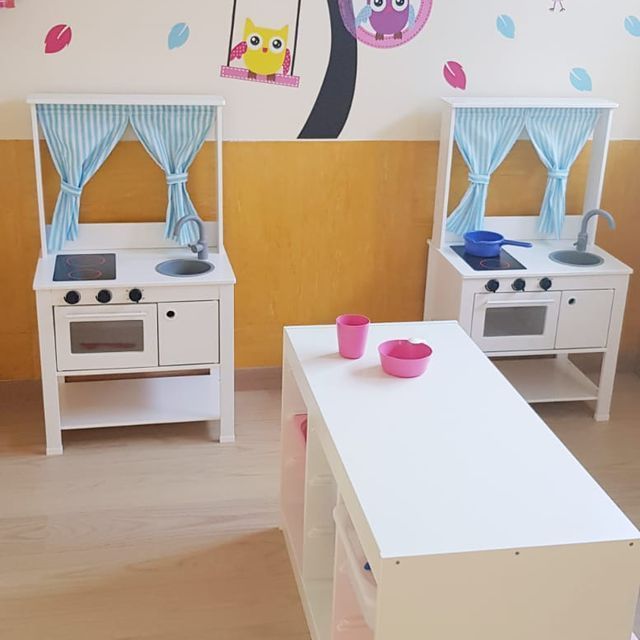 Una cocina de juguete para niños con búhos pintados en la pared.