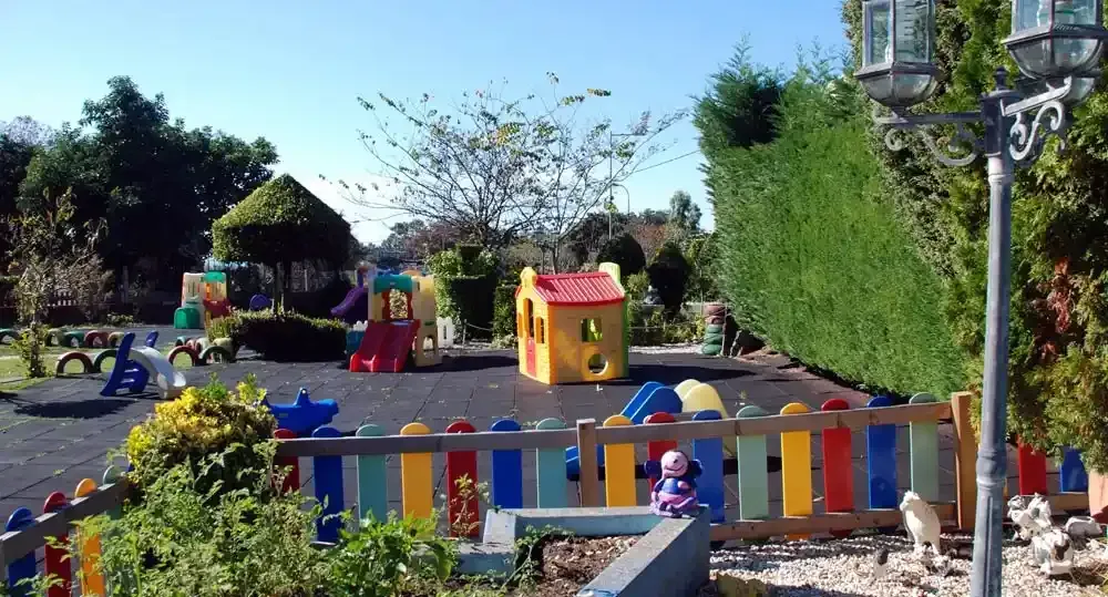 Un parque infantil colorido con una valla que lo rodea.