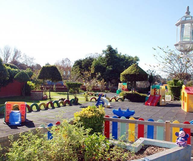 Un parque infantil con una valla de colores del arco iris.