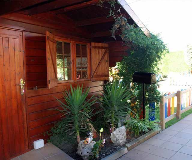 Una casa de madera con un buzón delante de ella.
