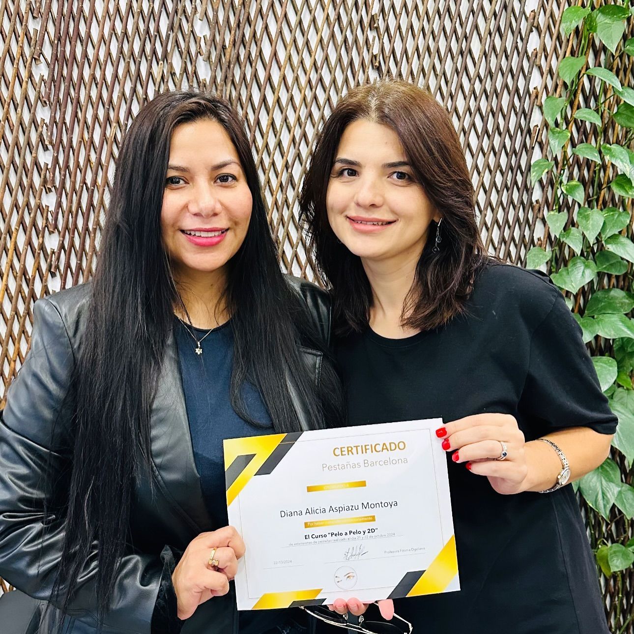 Dos personas sonrientes están de pie una al lado de la otra sosteniendo un certificado