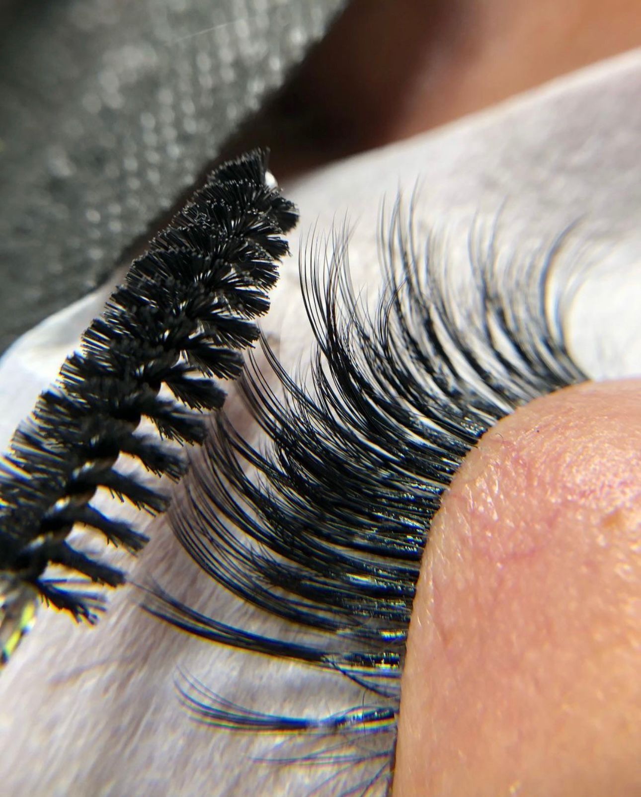 Se está utilizando un cepillo para pestañas postizas para peinar y separar las extensiones de pestañas largas