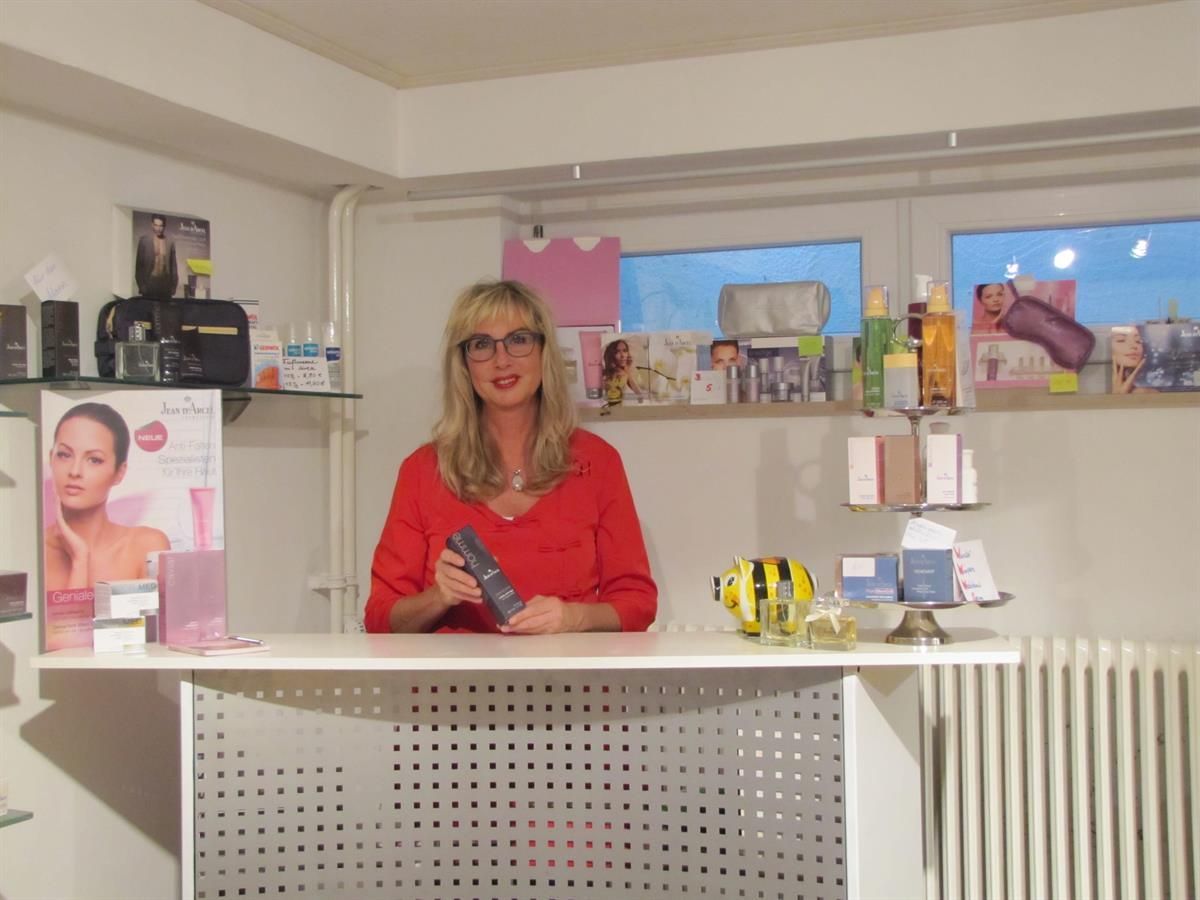 Eine Frau in einem roten Hemd steht hinter einer Theke