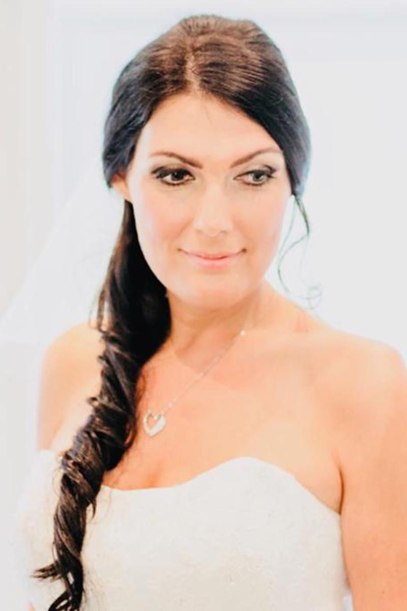 Die Frau trägt ein weißes Kleid und eine Halskette.