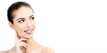 Eine Frau lächelt und berührt ihr Gesicht mit der Hand.