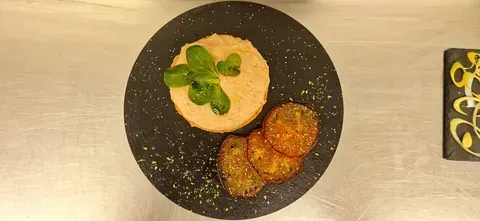 Un plato negro cubierto con comida y verduras sobre una mesa.