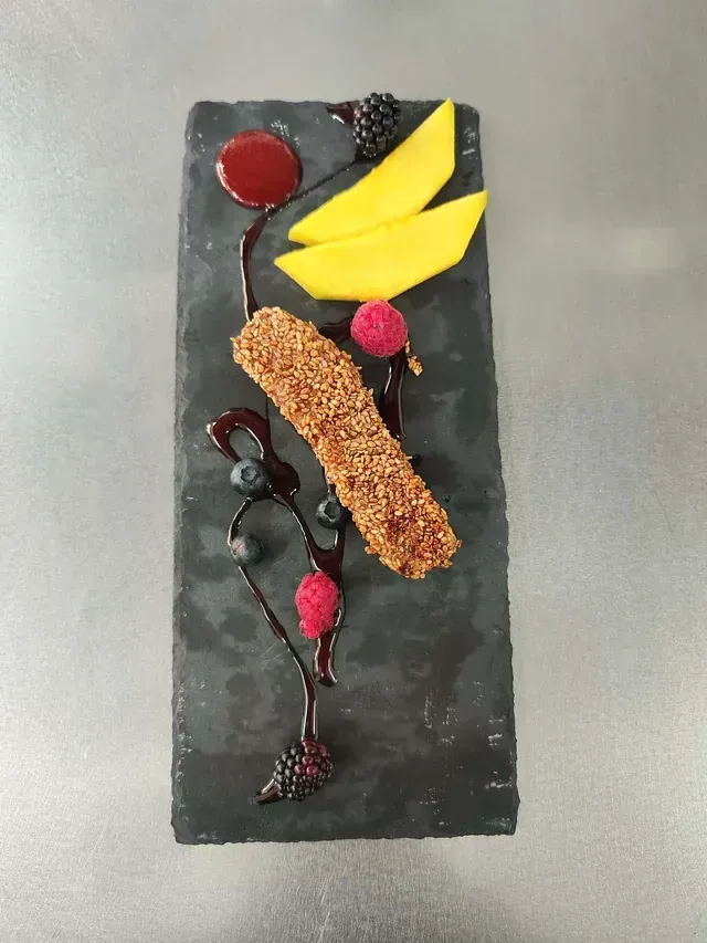 Un plato negro con un trozo de comida encima.
