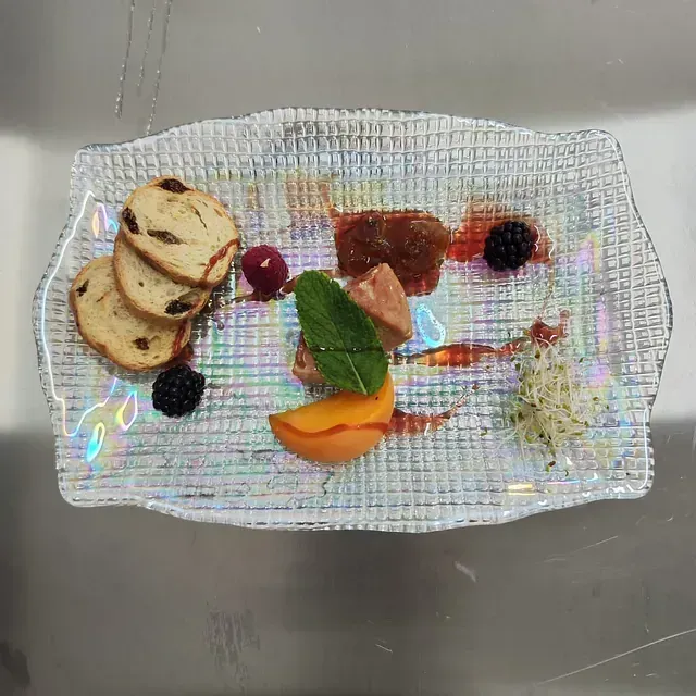 Un plato de comida con pan y fruta encima.
