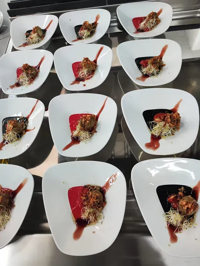 Un montón de platos blancos con comida en ellos.