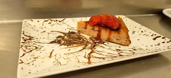Un plato blanco con un trozo de pastel encima.