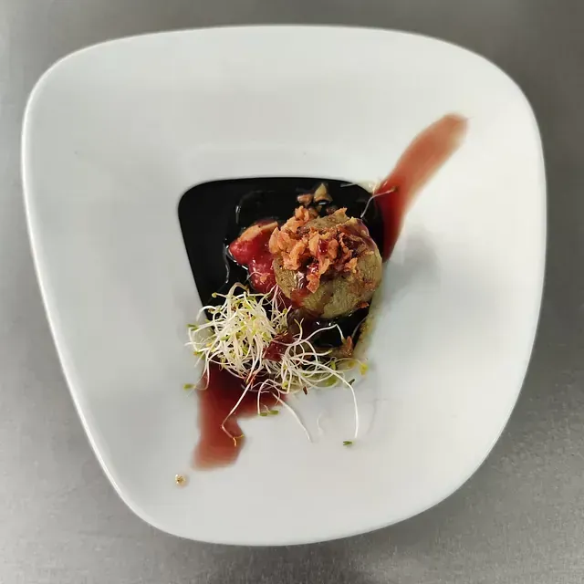 Un plato blanco con un trozo de comida encima.