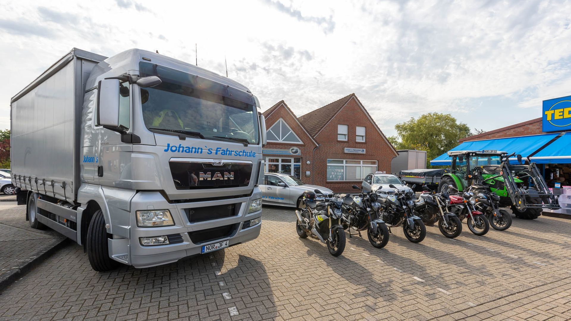 Ein MAN-LKW ist vor einer Reihe von Motorrädern geparkt.