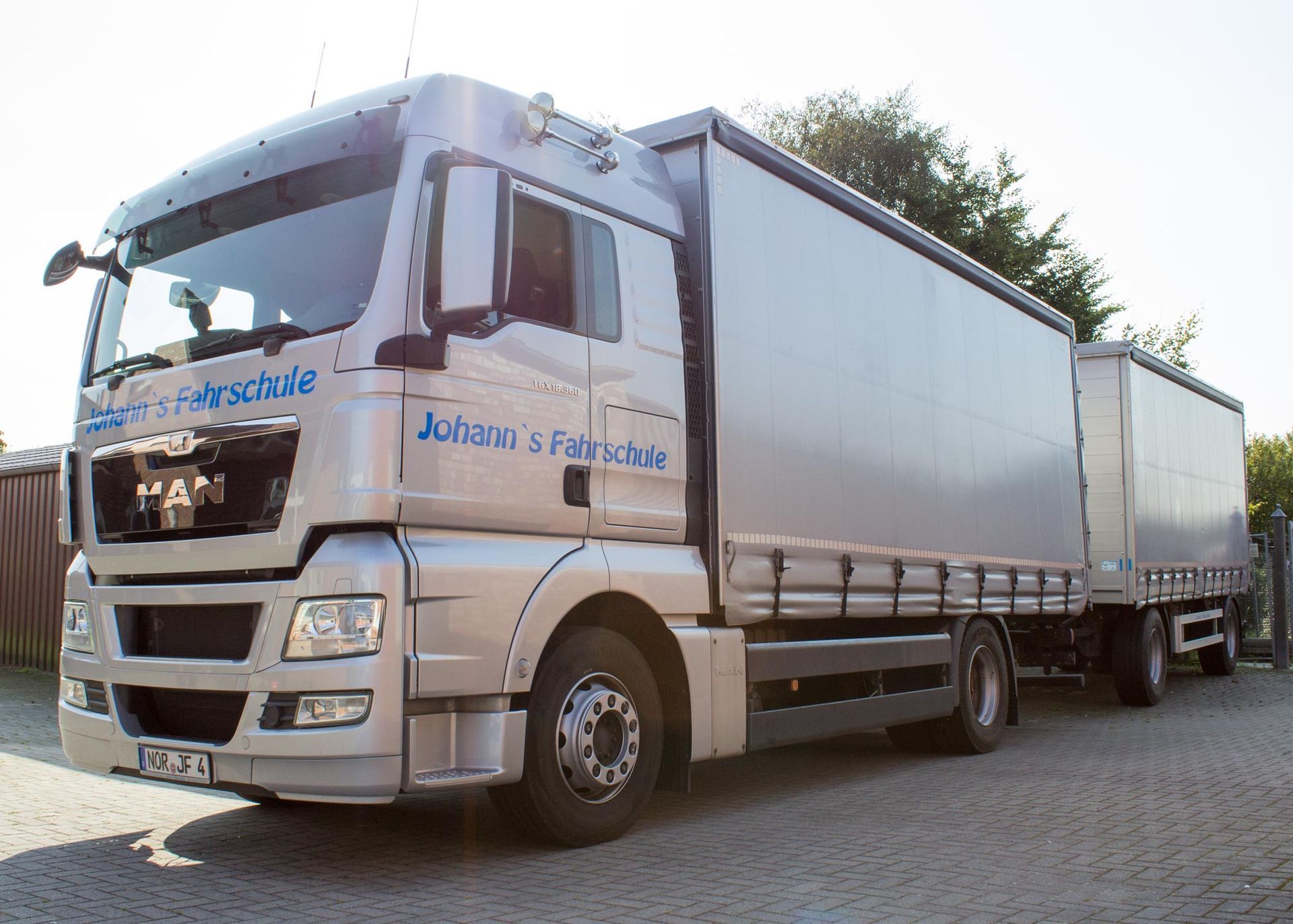 Ein MAN - Lastwagen mit Anhänger steht am Straßenrand.